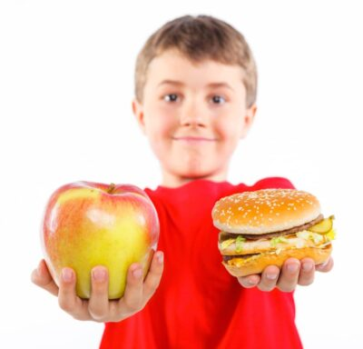 Child holding apple and hamburger